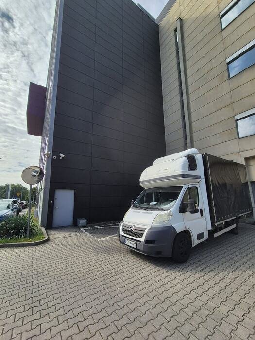 Bus przeprowadzkowy na tle biurowca – przeprowadzki firm i biur